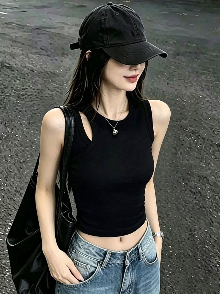 Woman in a black cap and tank top with blue jeans, showing her midriff