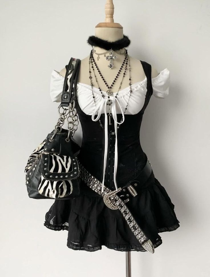 Gothic-style outfit on a mannequin with a black corset dress and layered jewelry