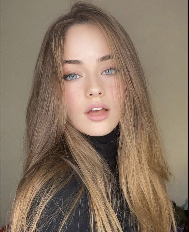 Woman with long hair and blue eyes wearing a black turtleneck