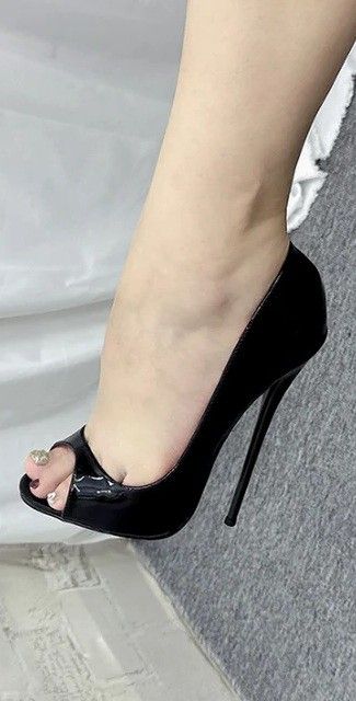 Foot in a black peep-toe stiletto heel with a decorated big toe nail