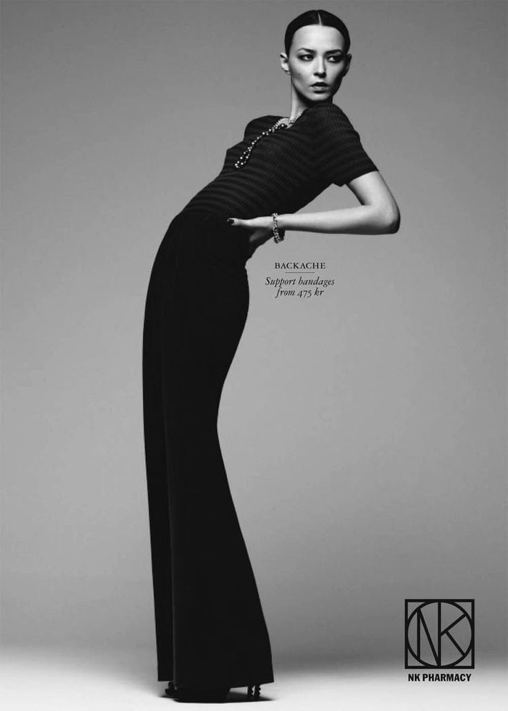 Woman in black top and pants posing dramatically in a studio