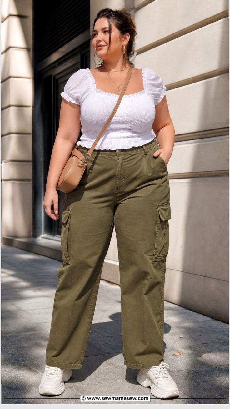 Woman in a white top and olive cargo pants with a crossbody bag outdoors