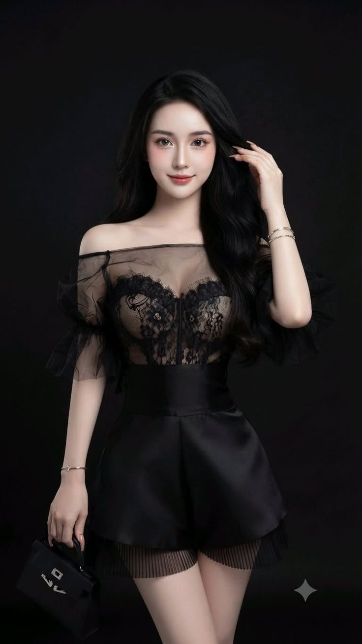 Woman with long black hair wearing a sheer lace top and black shorts