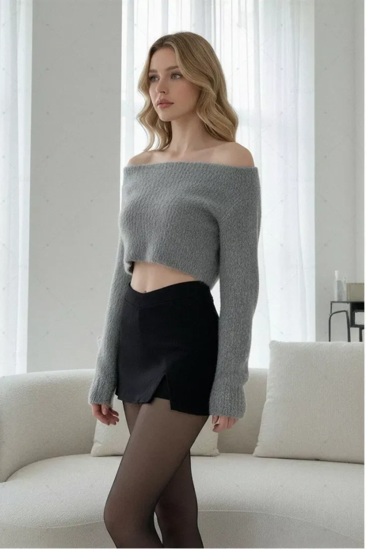 Woman with blonde hair wearing an off-shoulder crop top and black skirt with tights
