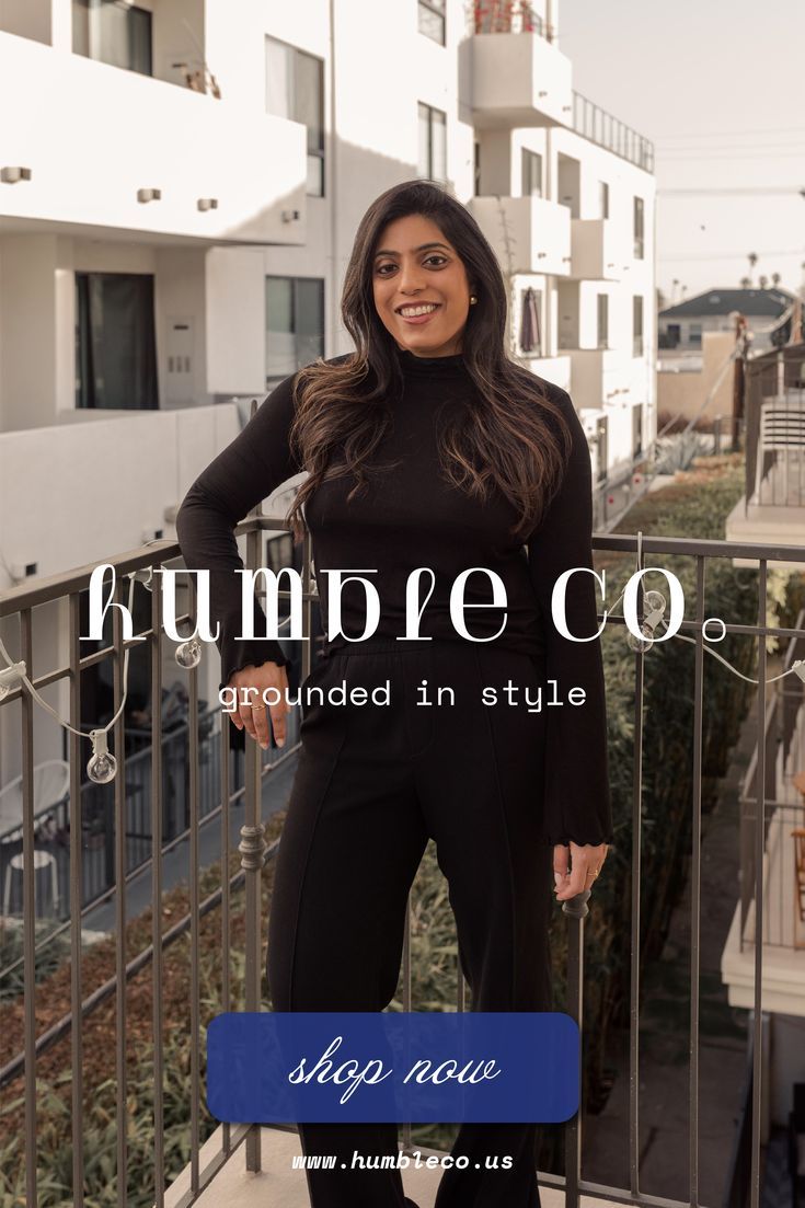 Woman in a black top and pants standing on a balcony