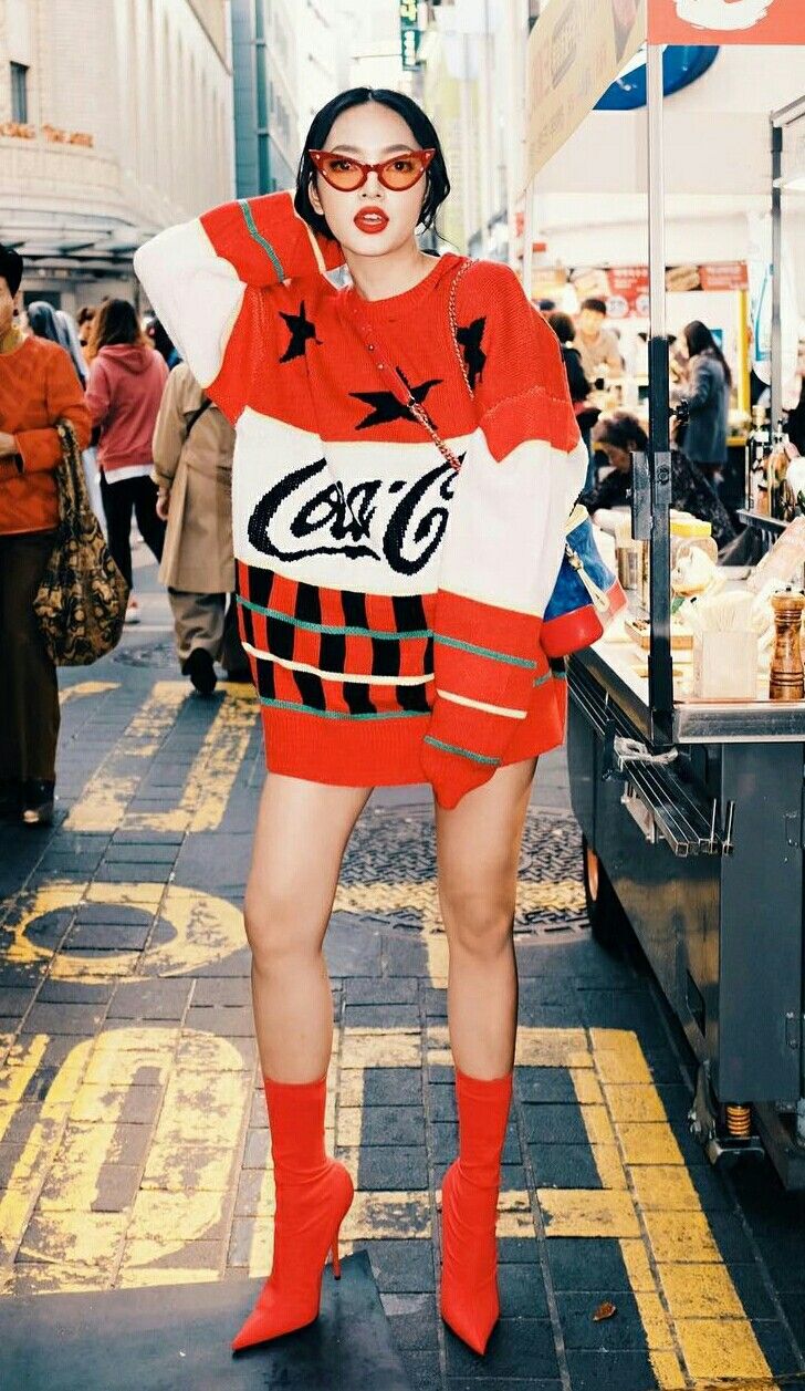 Woman in an oversized Coca-Cola sweater and red boots on a street