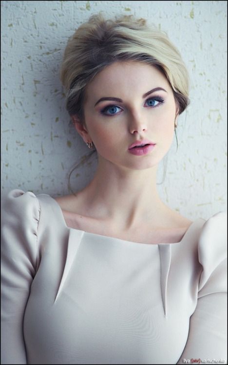 Woman with blonde hair and blue eyes in a light colored dress