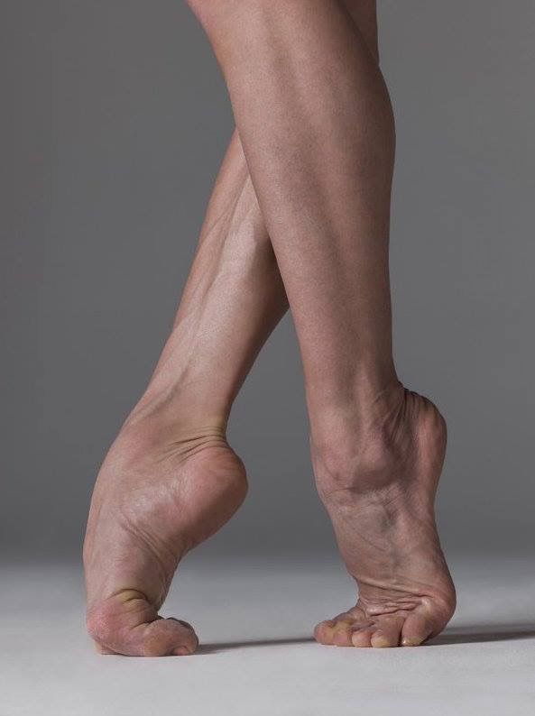 Close up of a dancer's legs and feet in a ballet pose