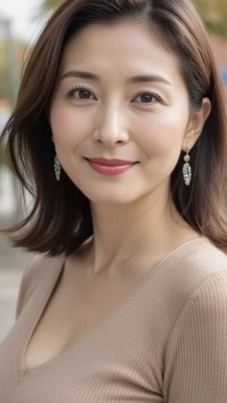 Woman with short brown hair and earrings wearing a v-neck top
