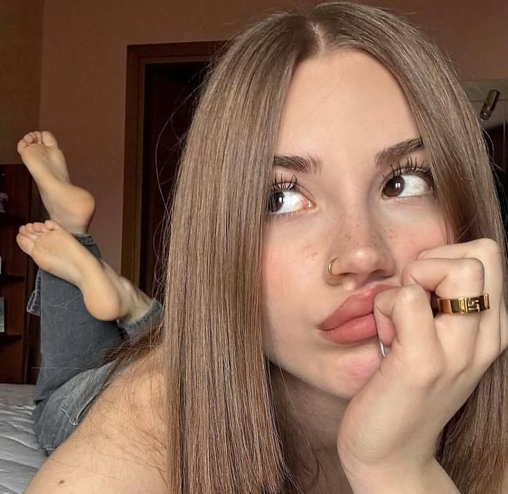 Woman with long hair and freckles posing indoors with exposed skin