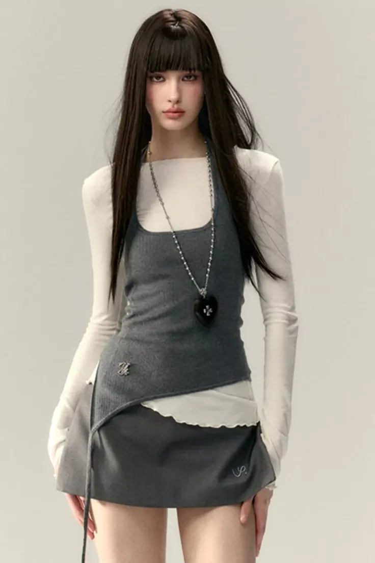 Woman with long dark hair wearing a layered top and mini skirt