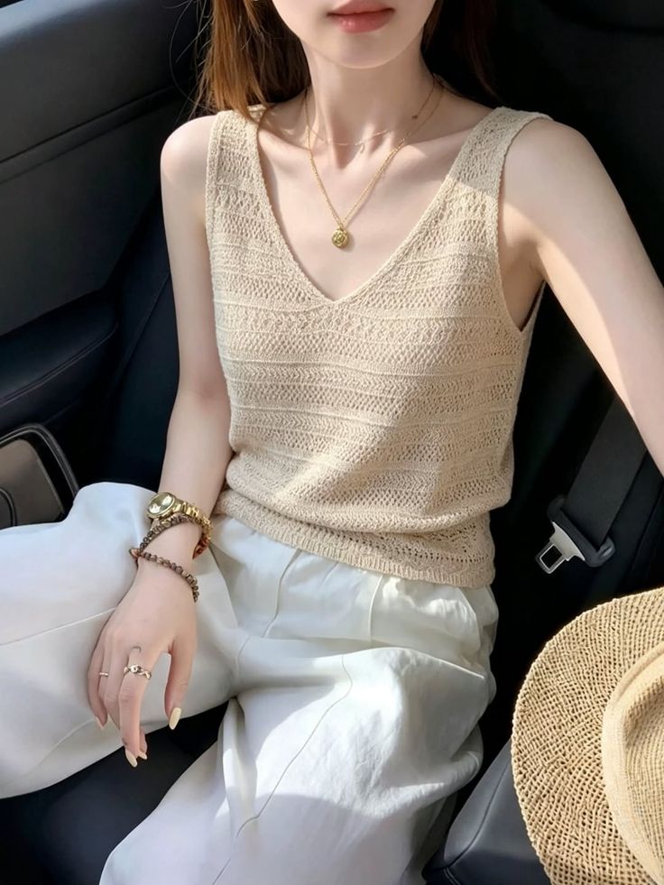 Woman in a knitted top and white pants sitting in a car