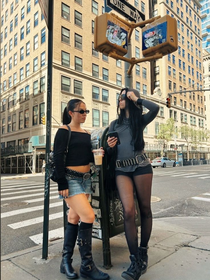 Two women in casual outfits and sunglasses on a city street