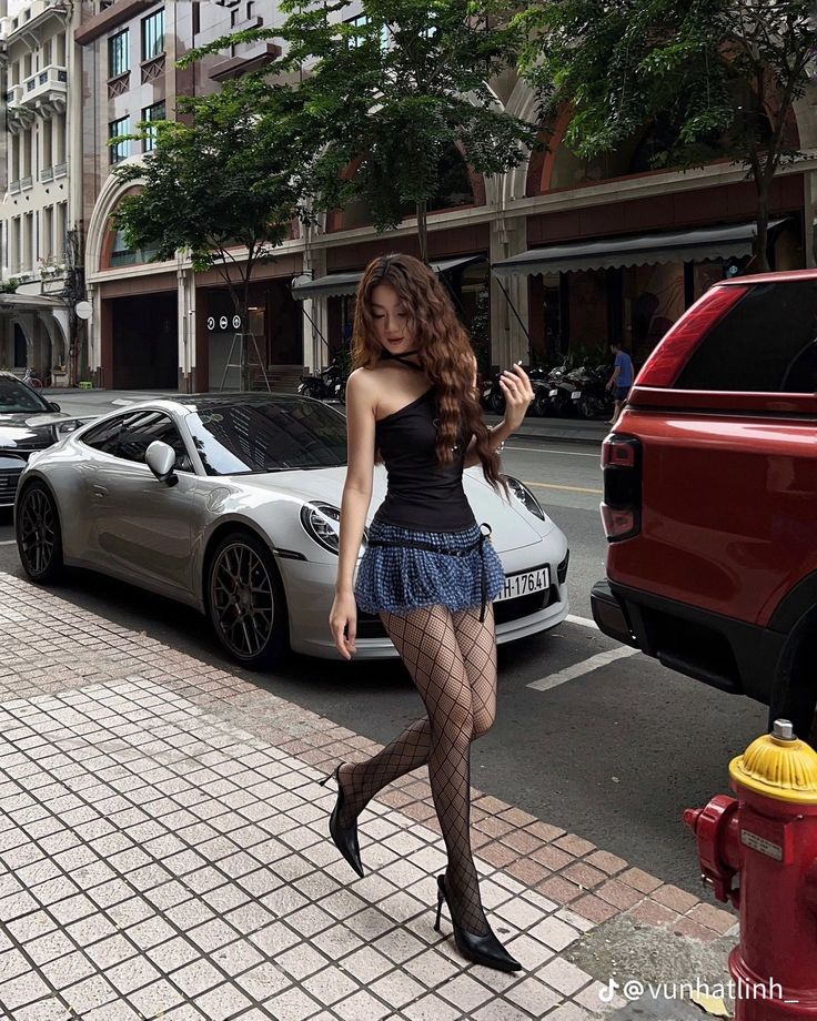 Woman in a mini skirt and fishnet stockings walking on a city street