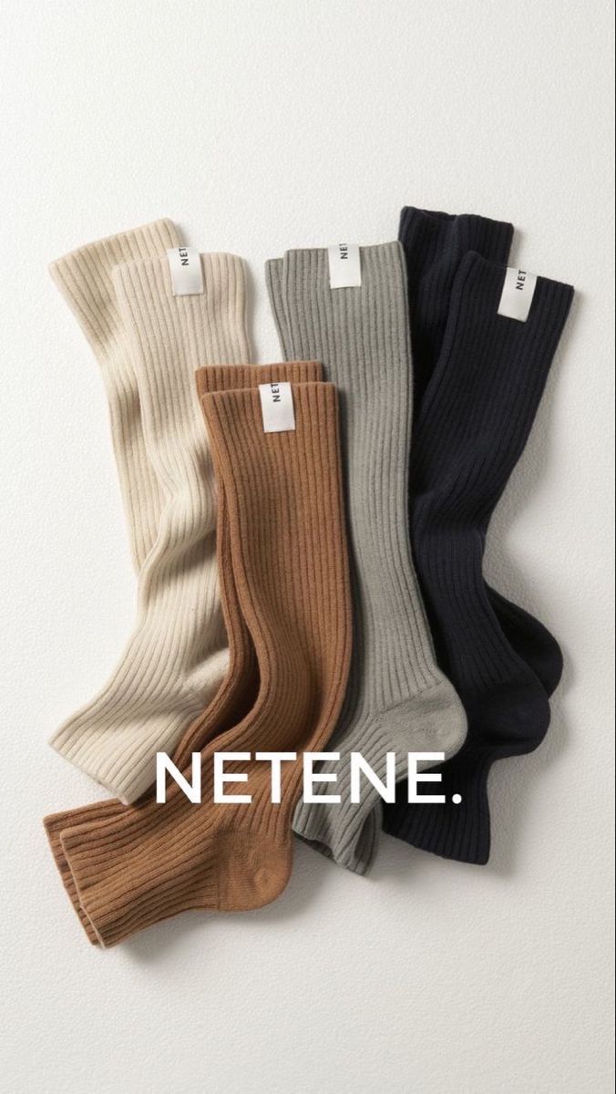 Four pairs of ribbed socks in neutral colors on a white background