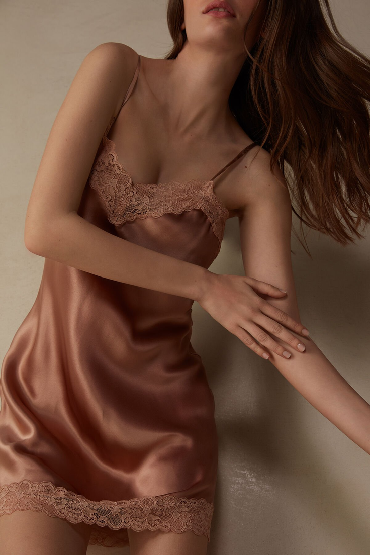 Woman in a satin and lace slip with long brown hair