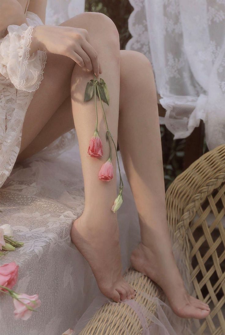 Woman in a lace dress holding pink flowers against her leg