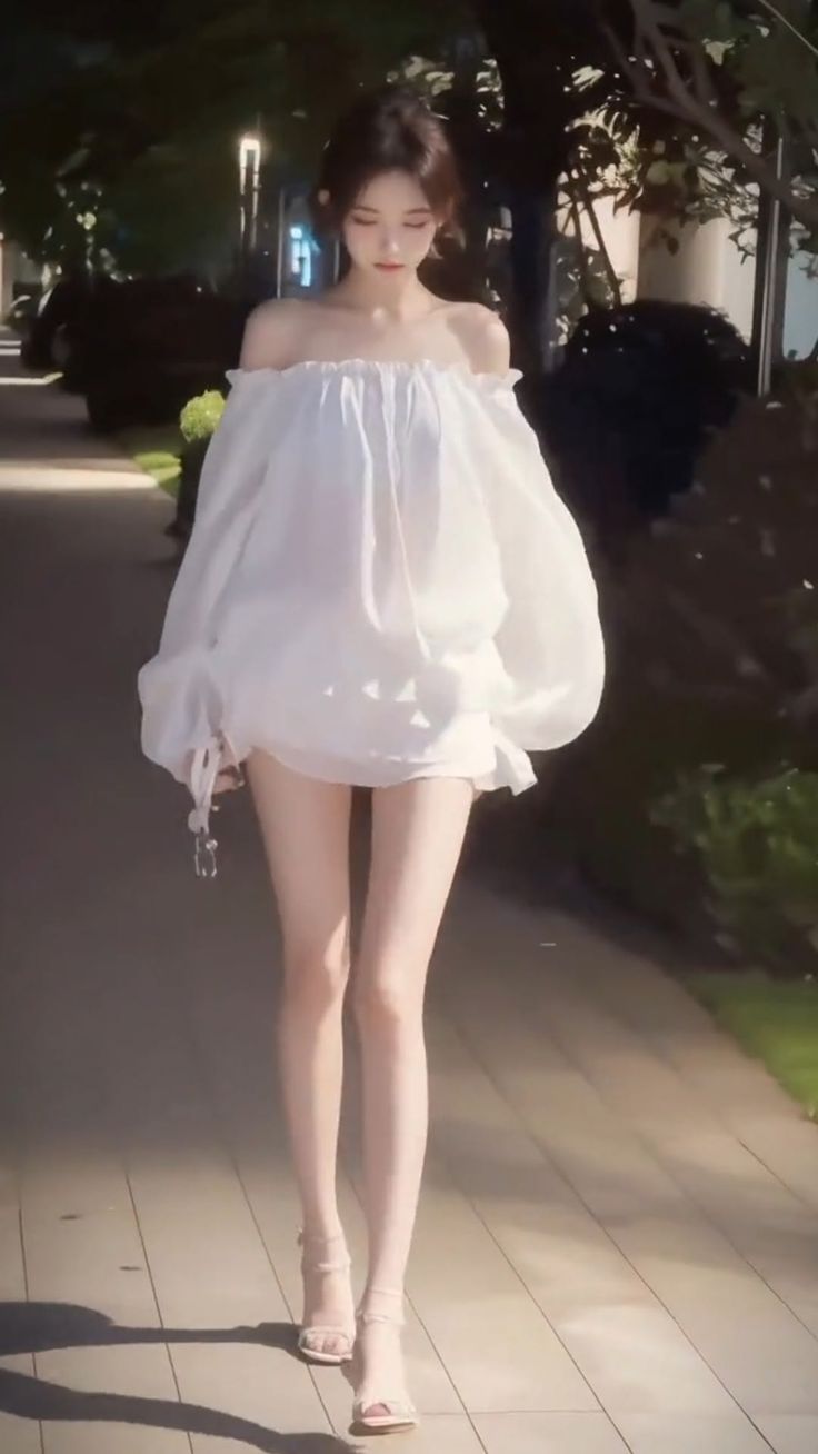 Woman in an off-shoulder top and high heels walking outdoors at night
