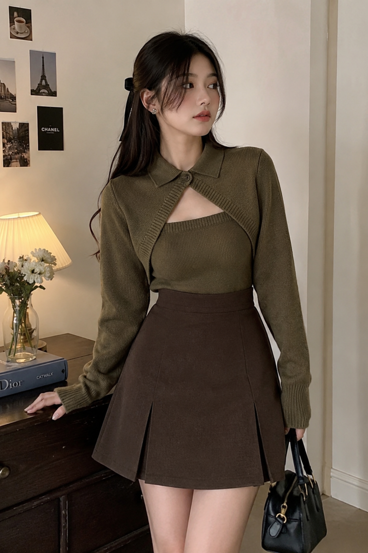 Woman in a brown skirt and green cropped cardigan indoors