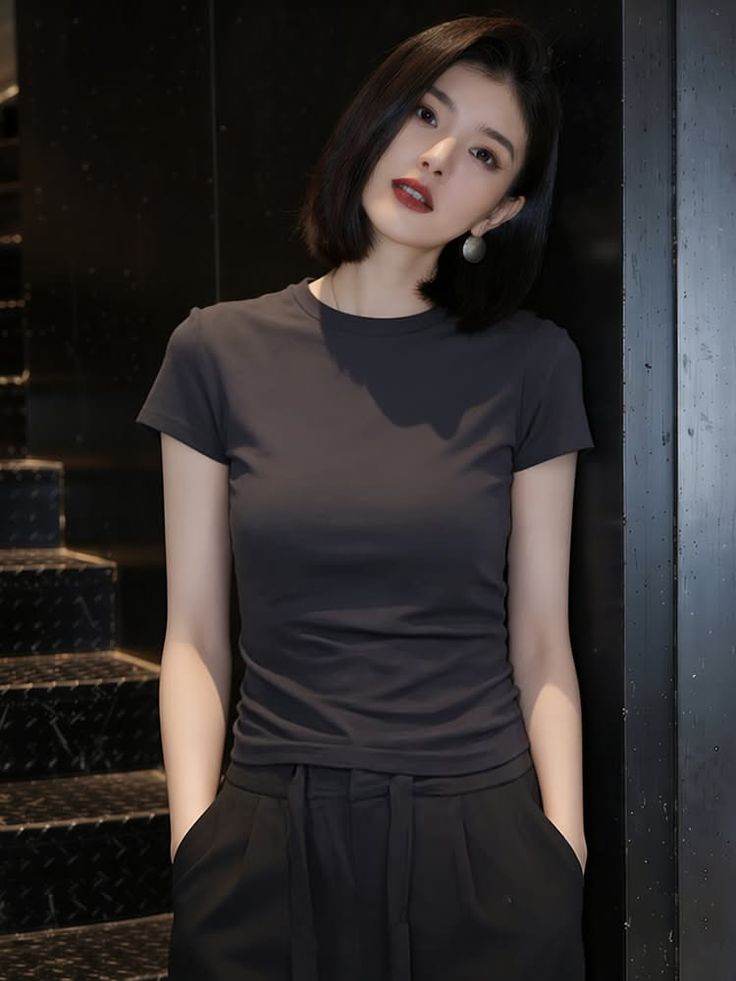 Woman with short dark hair and red lipstick in a dark room