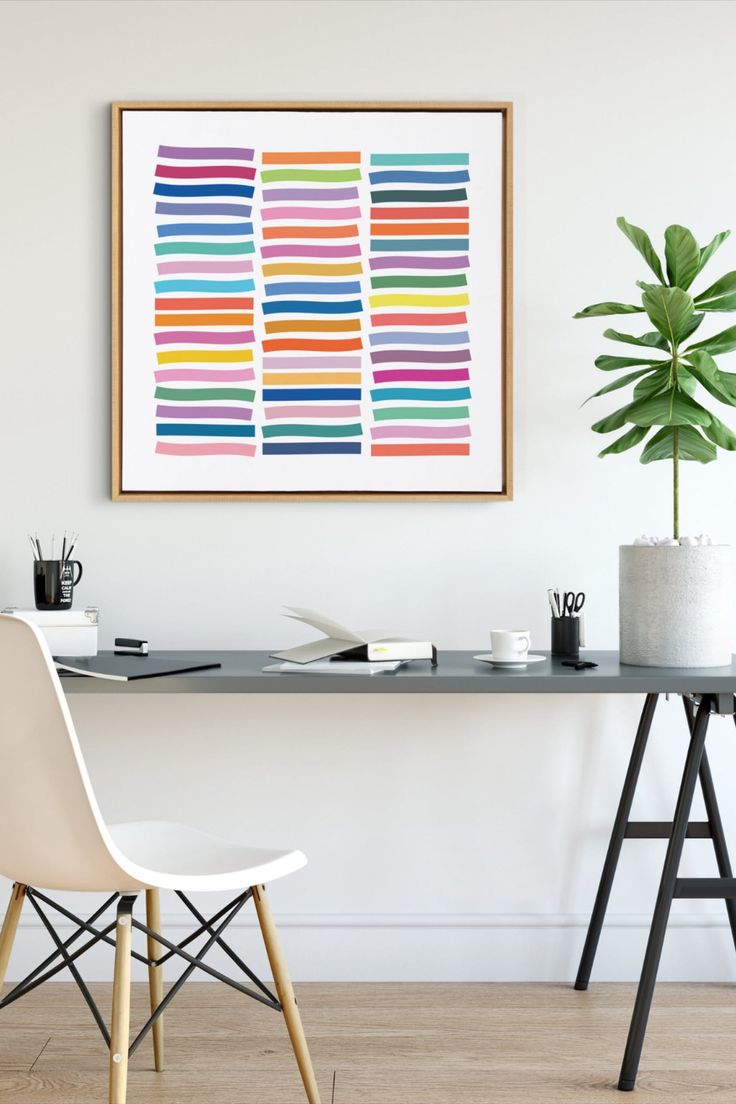 Home office with a colorful abstract art print above a minimalist desk