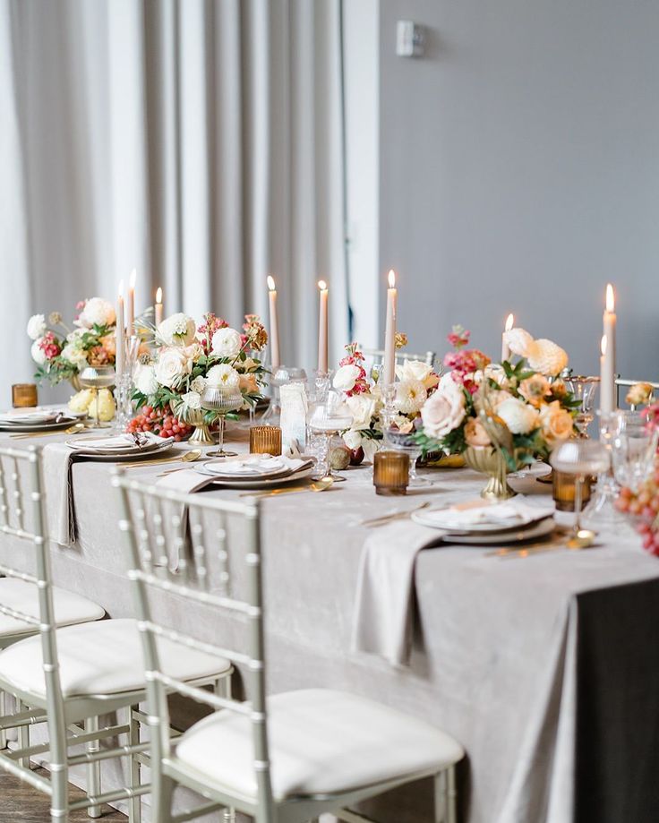 Elegant dining table set with floral arrangements and lit candles