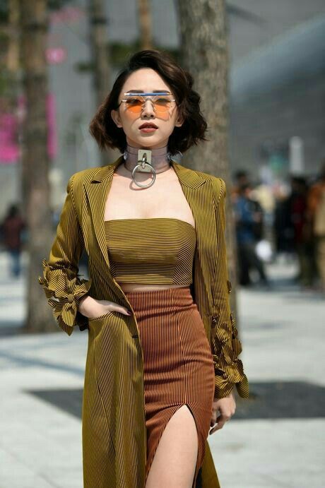 Woman in a striped outfit with a choker and sunglasses outdoors