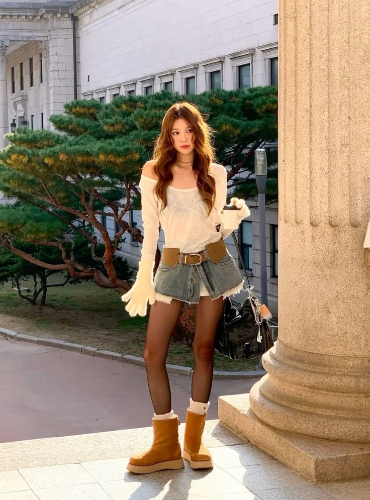 Woman with long hair wearing a denim skirt and off-shoulder top outdoors