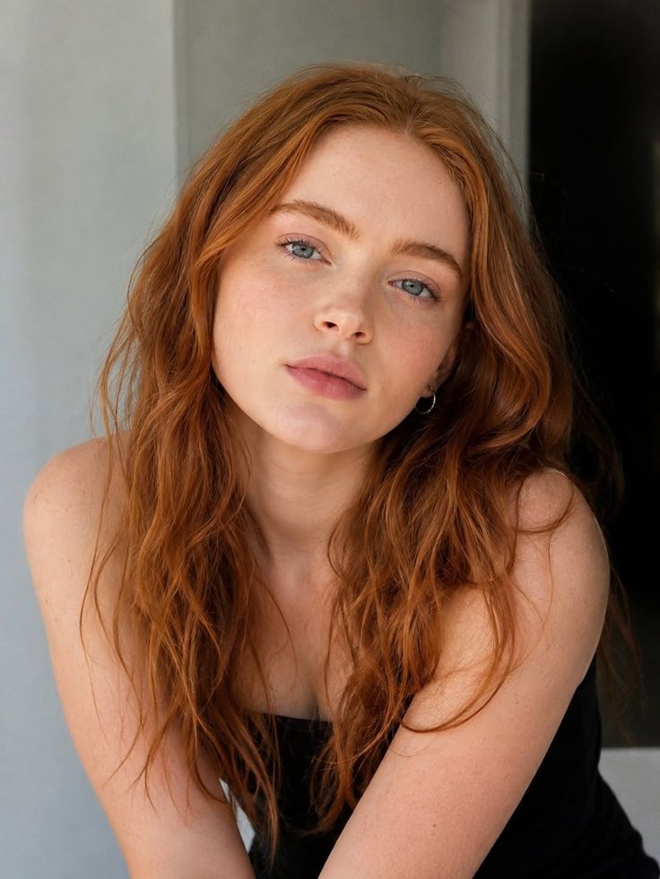 Woman with red hair and blue eyes wearing a strapless top
