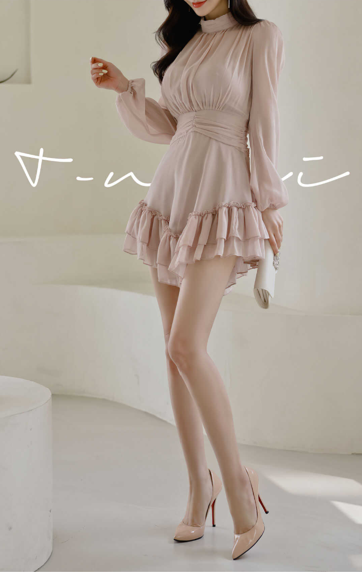 Woman in a pink ruffle dress and high heels holding a white clutch