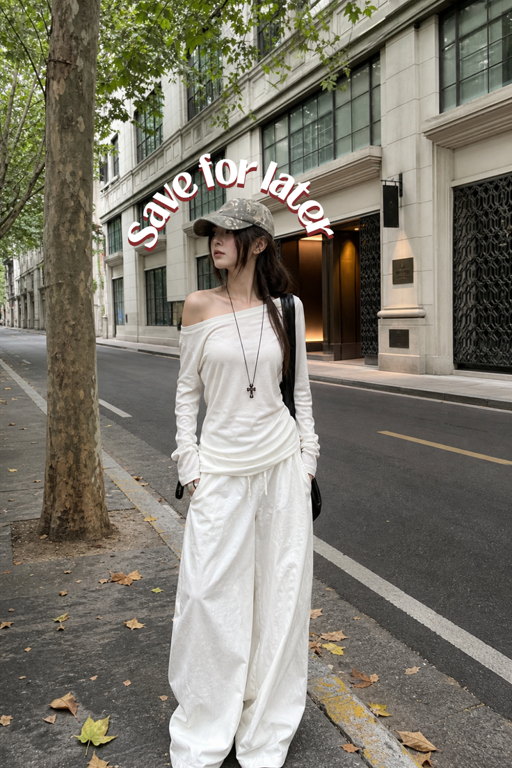 Woman in an off-shoulder top and wide-leg pants on a city street
