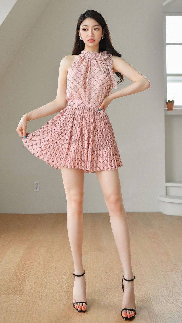 Woman in a pink patterned dress and black high heels posing indoors