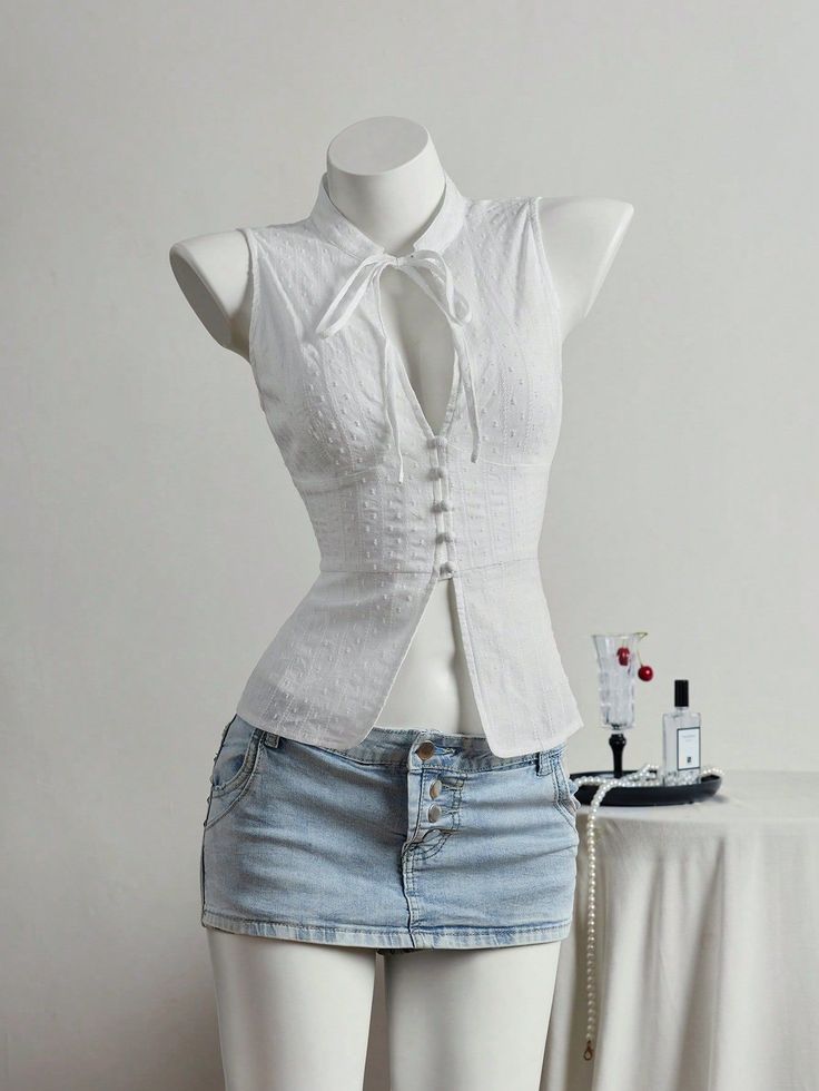Mannequin wearing a white sleeveless top and a denim mini skirt