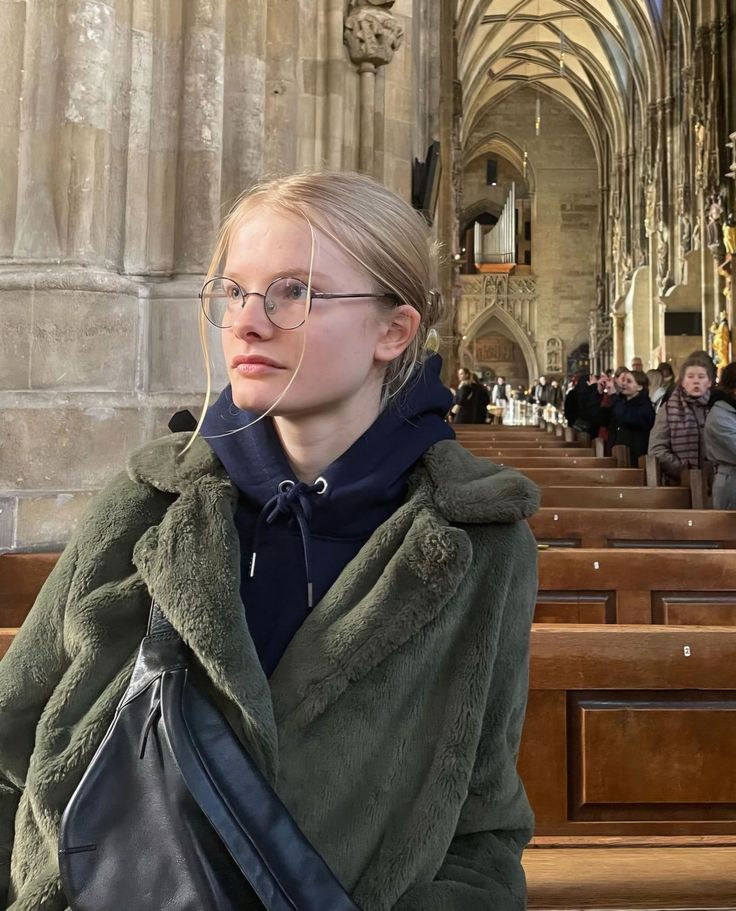 Young woman with blonde hair and glasses in a church