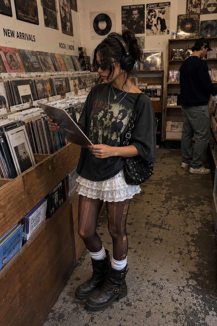 Woman in a record store wearing headphones and a graphic t-shirt