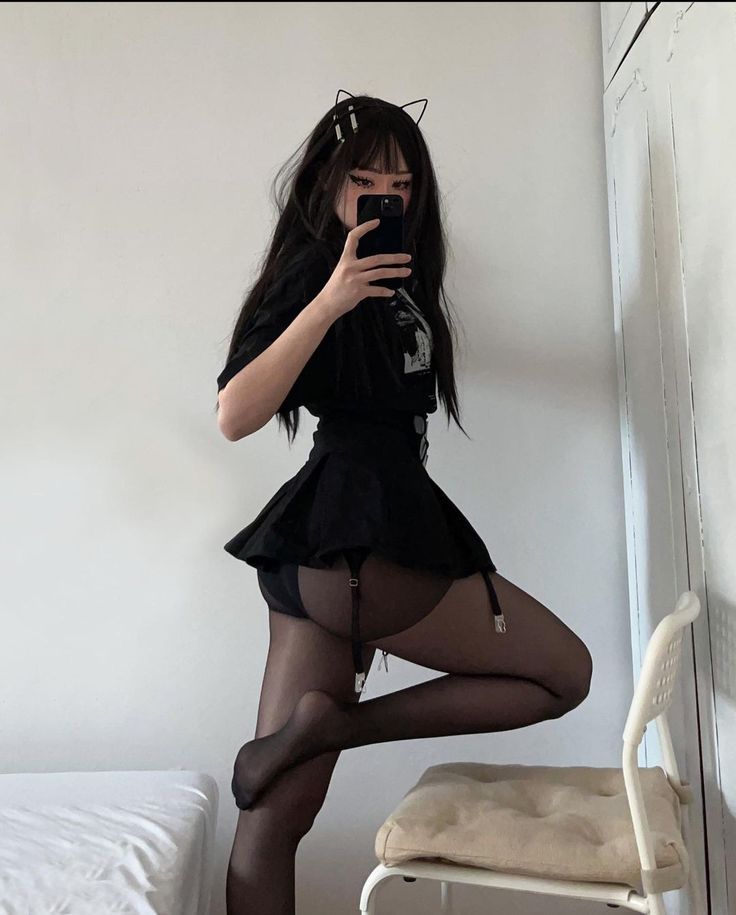 Woman in a black mini skirt and garter belt posing indoors