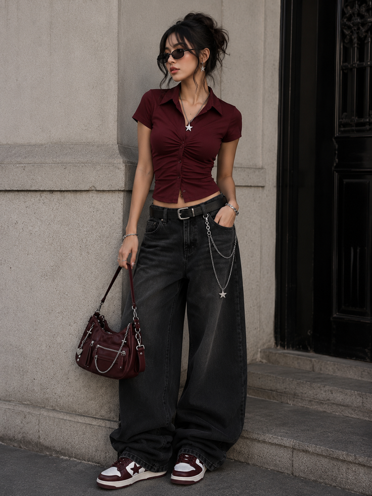 Woman in a cropped maroon top and baggy jeans with star accessories
