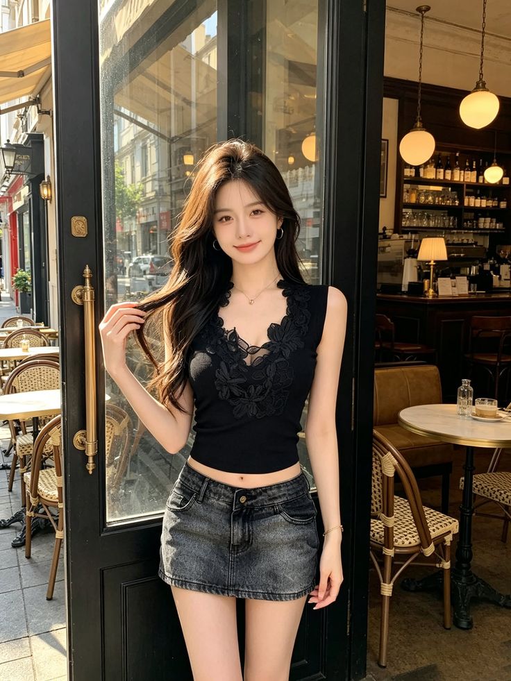 Woman in a black top and denim skirt standing outside a cafe
