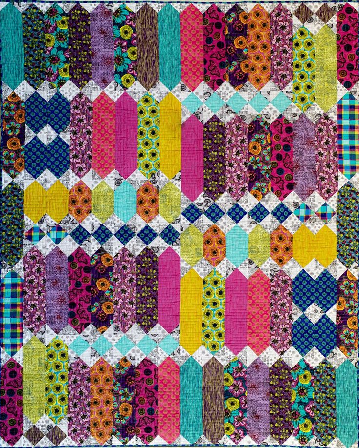 A colorful quilt with a geometric pattern made from various patterned fabrics