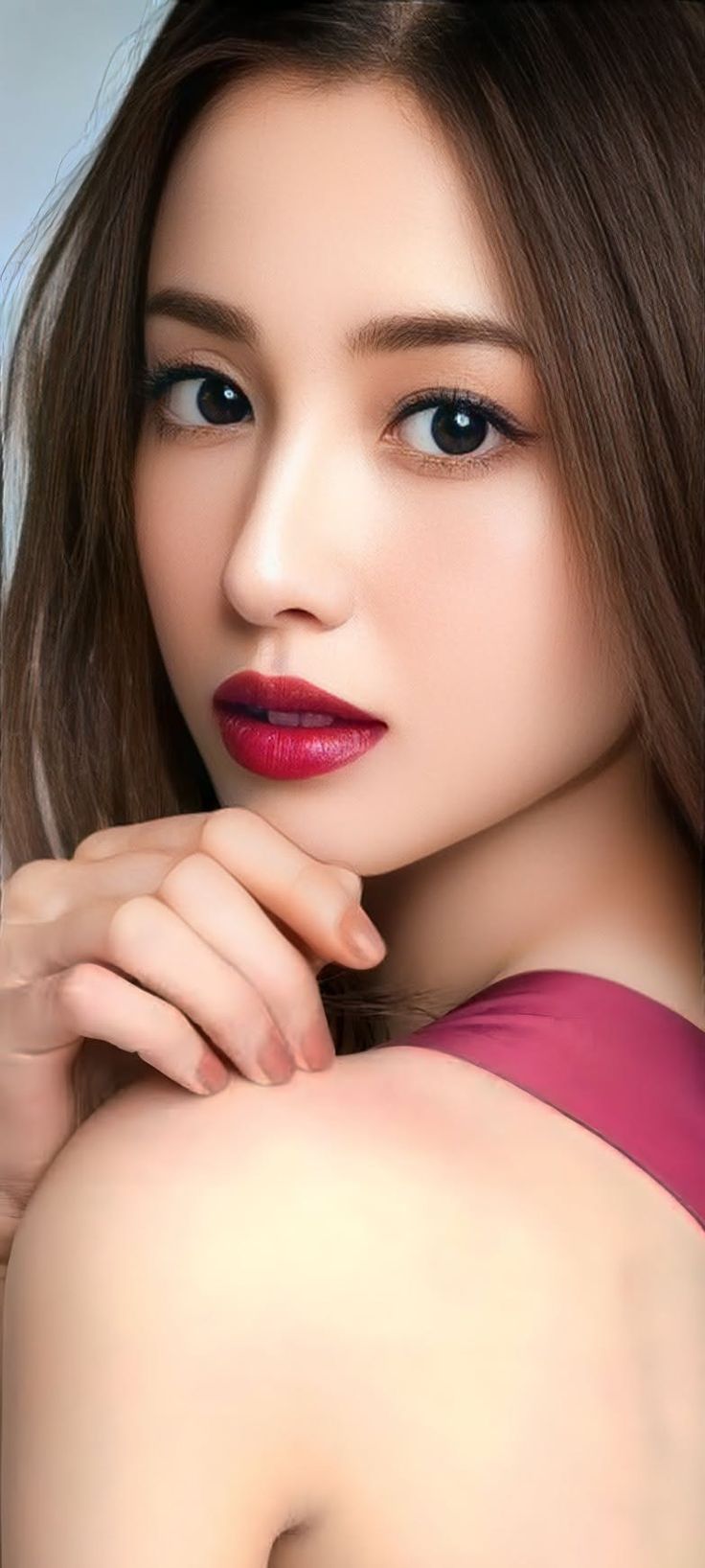 Woman with long hair and red lipstick, with one shoulder exposed