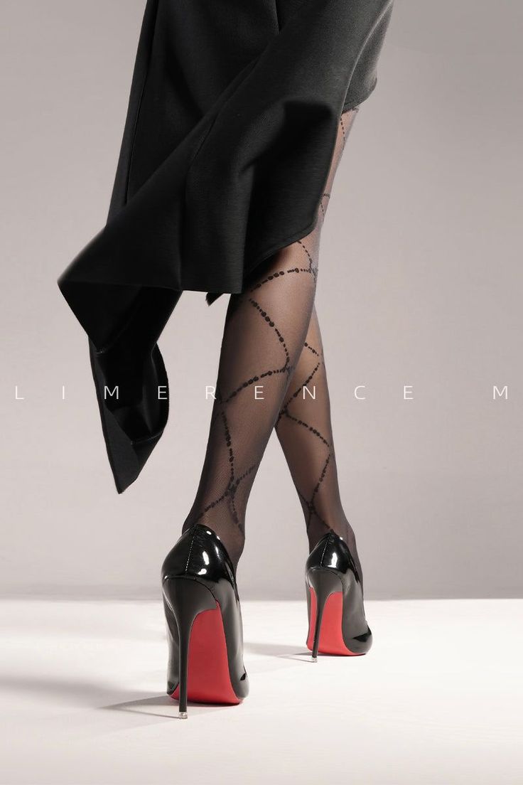 Lower body of a person in black high heels and patterned tights