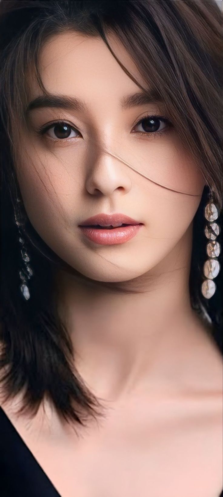 Close up portrait of a woman with long dark hair and earrings