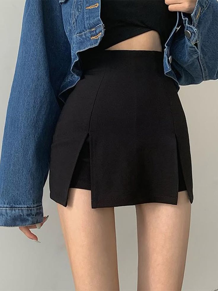 Person in a denim jacket, black crop top, and black high-waisted skirt