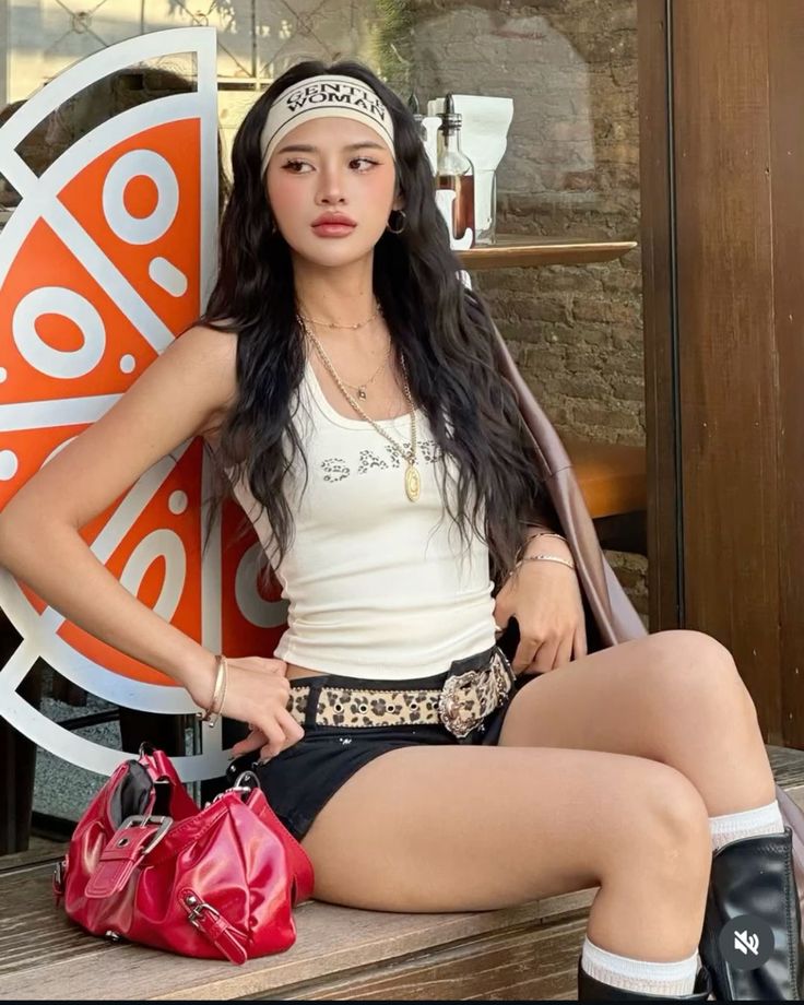 Woman with long hair wearing a white tank top and black shorts outdoors