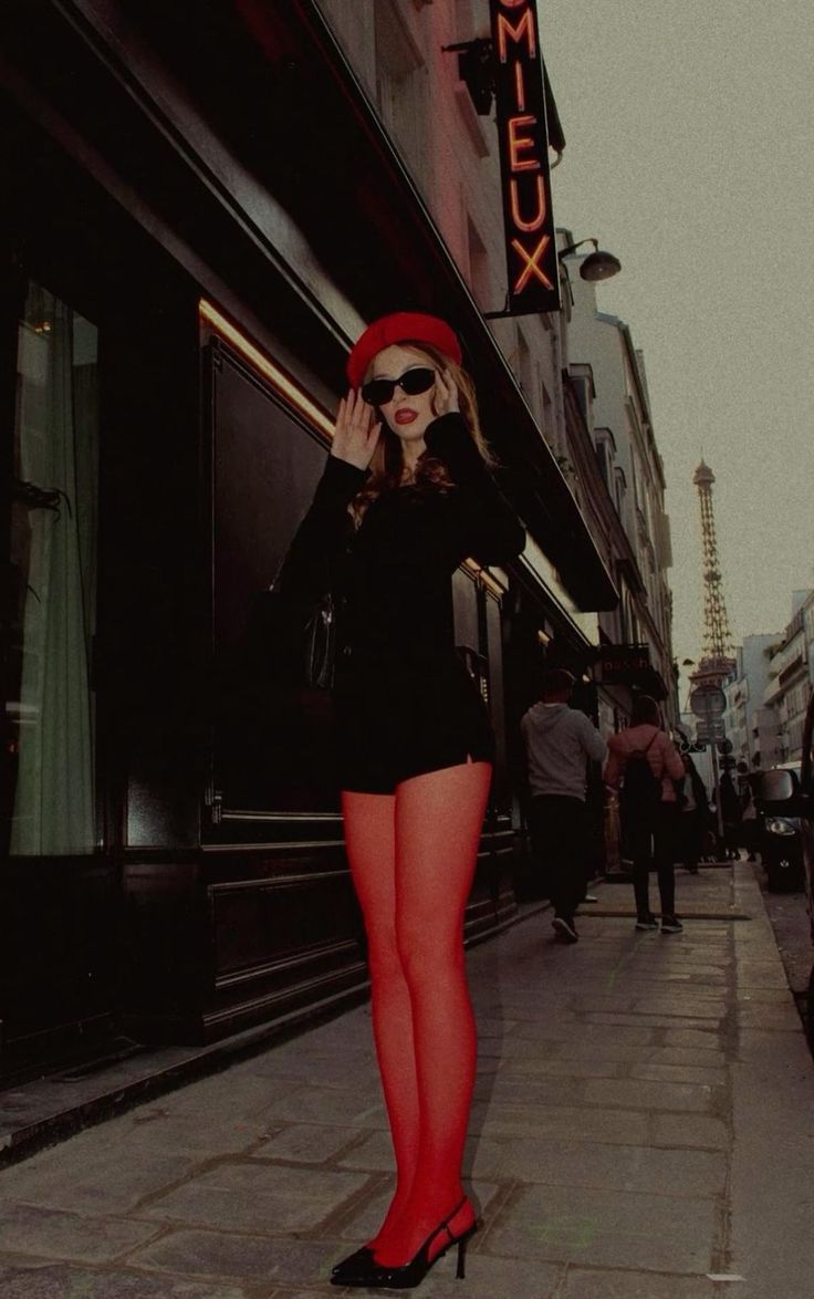 Woman in a red beret and red tights on a street with the Eiffel Tower in the background