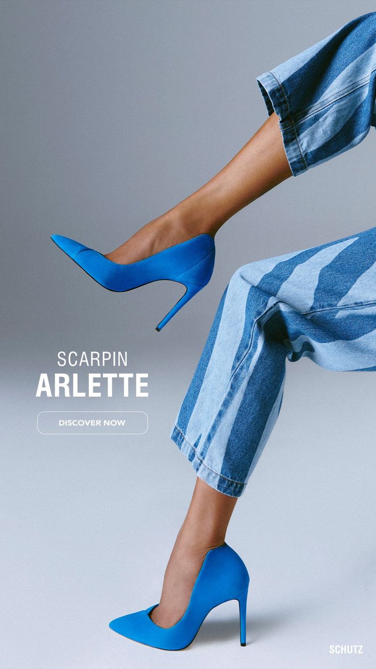 Person wearing blue high heels and striped jeans in a studio setting