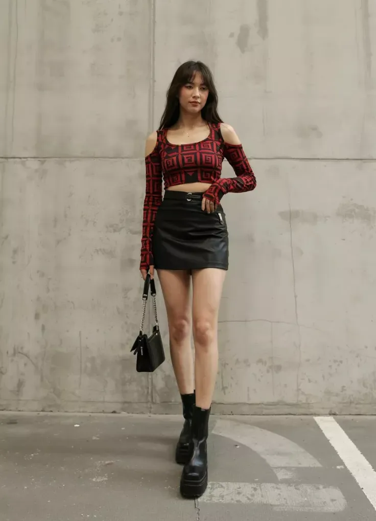 Woman in a red patterned crop top and black mini skirt with platform boots
