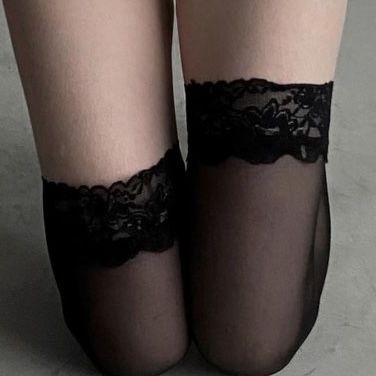 Close up of legs wearing sheer black ankle socks with lace trim