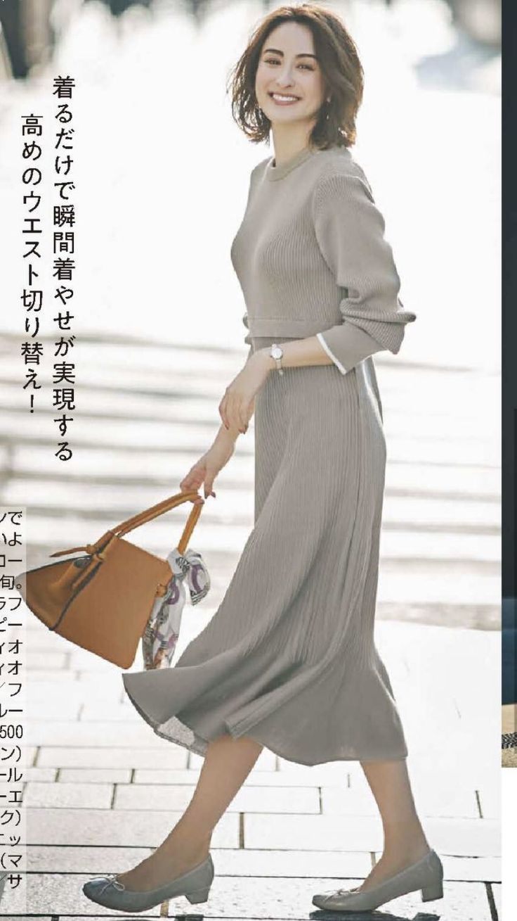 Woman in a ribbed dress and heeled shoes carrying a brown handbag outdoors