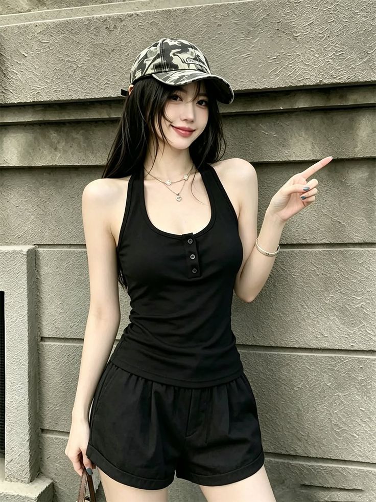 Woman in a black halter top and camouflage cap pointing to the side